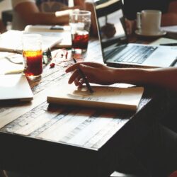 People at desk with laptop and drinks