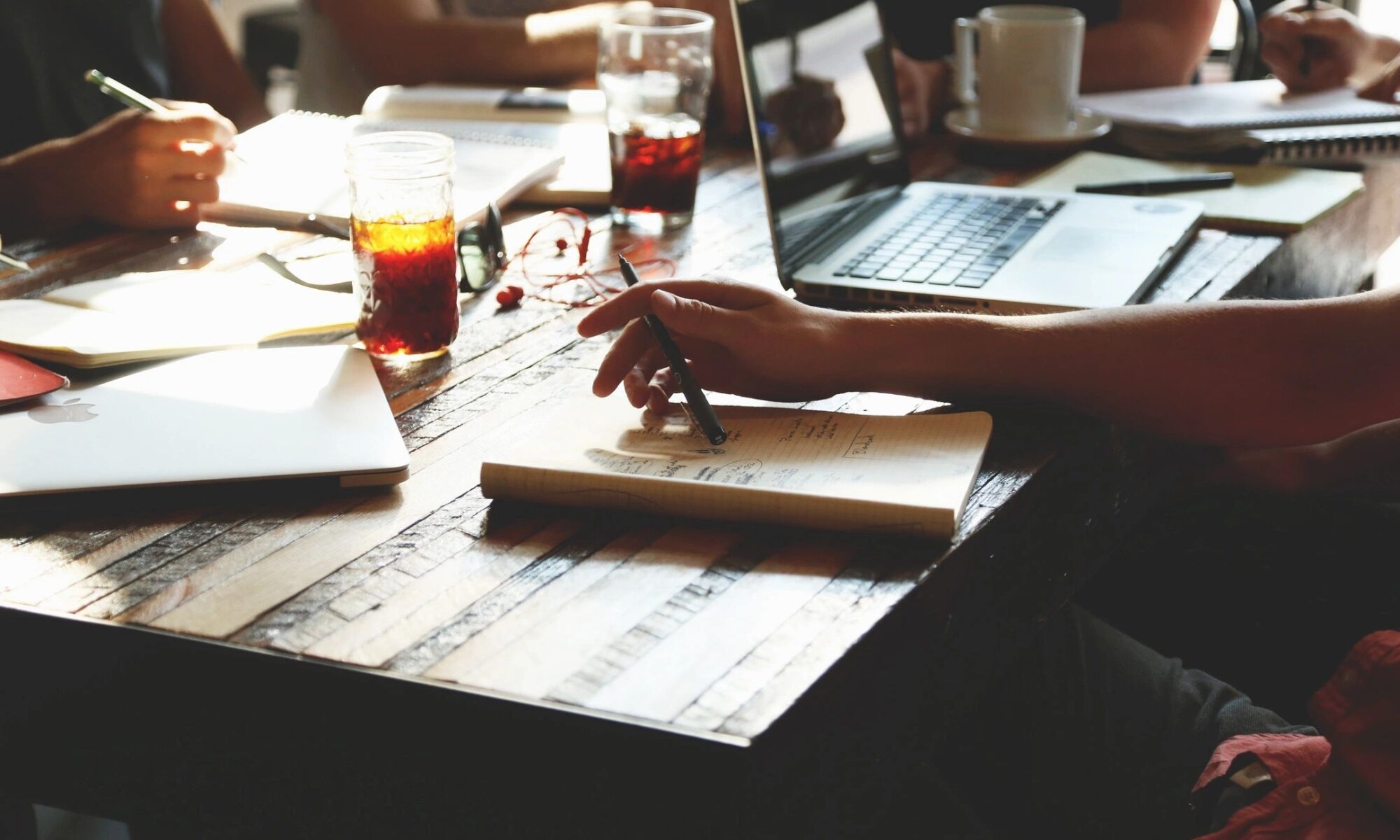 People at desk with laptop and drinks