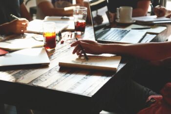 People at desk with laptop and drinks